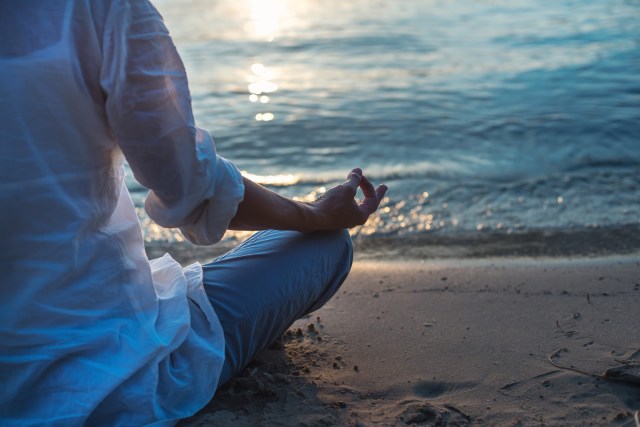 woman meditating by ocean