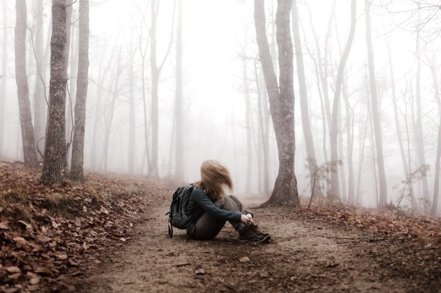 girl surrounded by trees in fog relaxed girl sitting in foggy forest surrounded by lots of trees