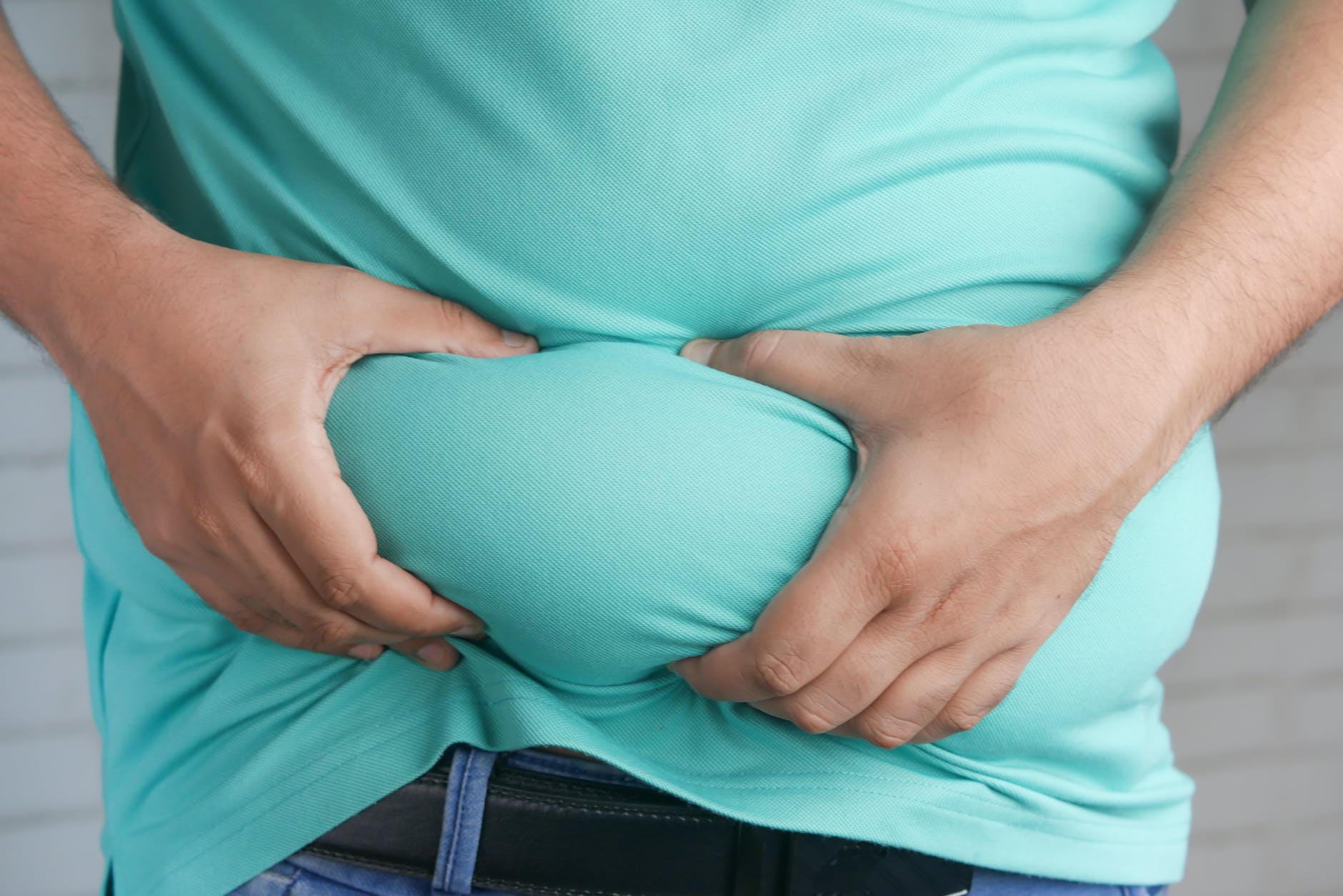 hands holding fat on belly